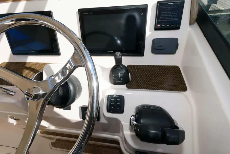 Slide: The Image of 2015 Grady-White Freedom 335 boat dashboard with steering wheel and navigation controls. - 10