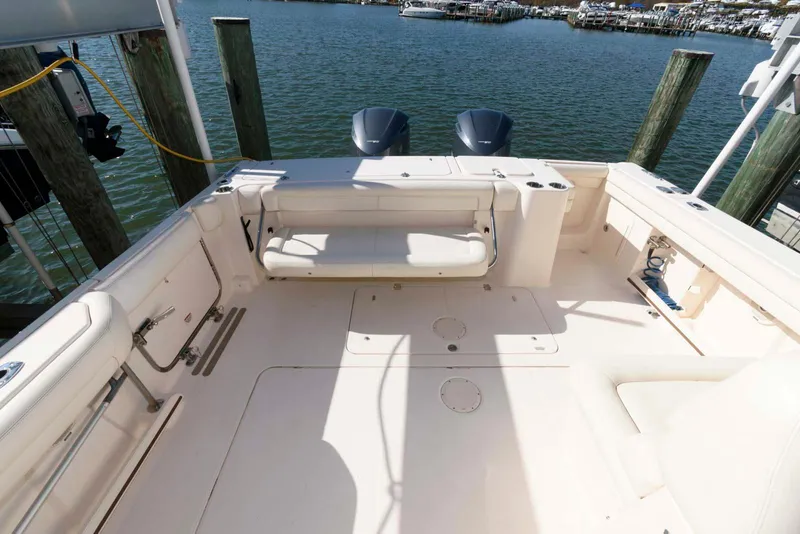 Slide: The Image of 2015 Grady-White Freedom 335 boat deck with seating, docked by the water. - 17