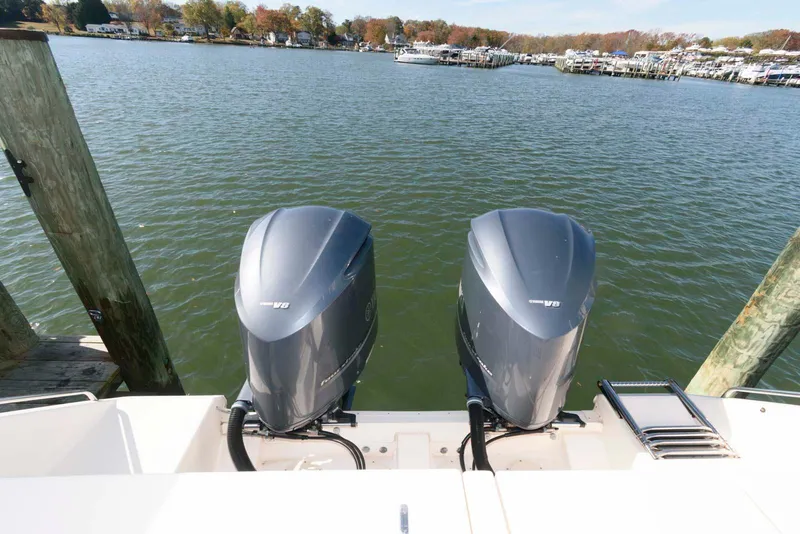 Slide: The Image of 2015 Grady-White Freedom 335 boat with dual outboard motors on a calm lake. - 25