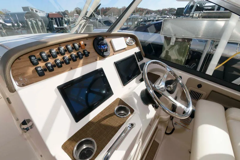 Slide: The Image of Helm of 2015 Grady-White Freedom 335 boat with modern controls and steering wheel. - 8