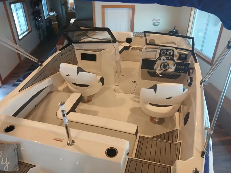 Slide: The Image of 2025 Starcraft SVX 190 OB boat interior with seating and steering console. - 2
