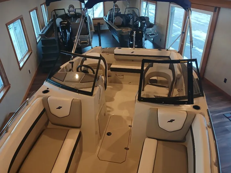 Slide: The Image of 2025 Starcraft SVX 190 OB boat interior with seating and windshield in showroom. - 4