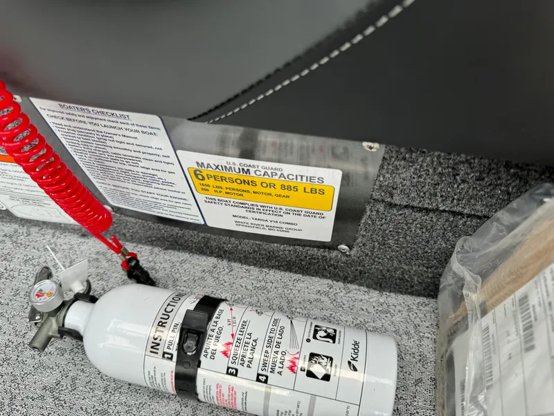 Slide: The Image of 2024 Tracker Targa V-18 Combo boat capacity label and fire extinguisher. - 13