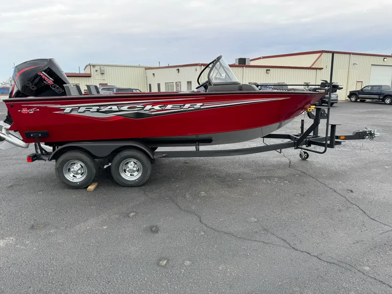 Slide: The Image of 2024 Tracker Targa V-18 Combo boat on trailer, red exterior, parked outdoors. - 3
