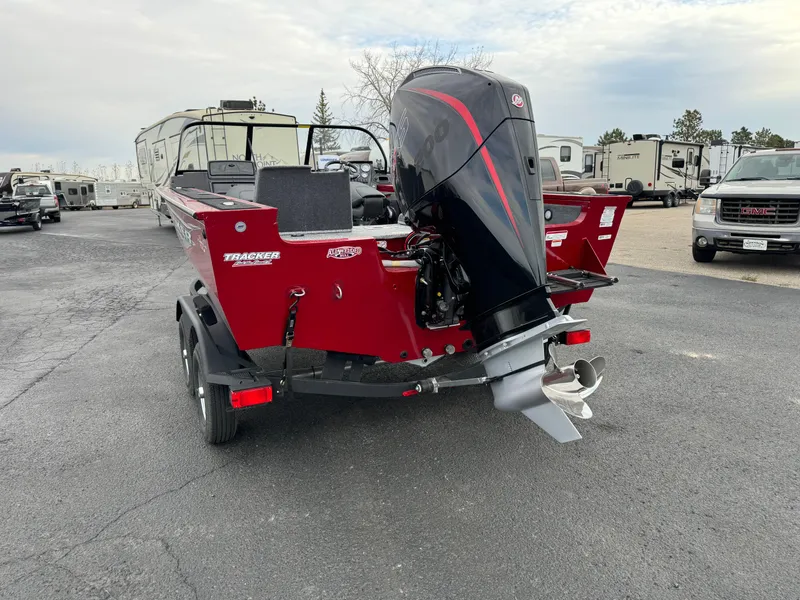 Slide: The Image of 2024 Tracker Targa V-18 Combo boat with outboard motor in a parking lot. - 4