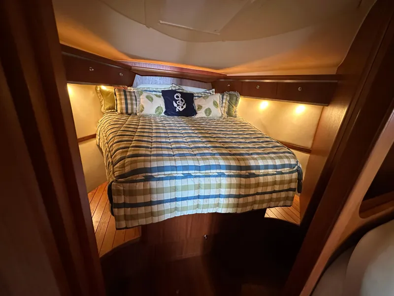 Slide: The Image of Cozy cabin interior of 2005 Tiara Yachts 3600 Sovran with plaid bedding and ambient lighting. - 30