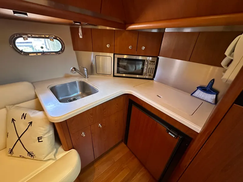 Slide: The Image of 2005 Tiara Yachts 3600 Sovran galley with sink, microwave, and compact fridge. - 34