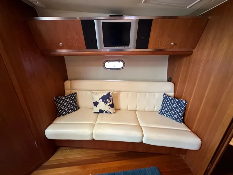 Slide: The Image of 2005 Tiara Yachts 3600 Sovran interior with white sofa, nautical pillows, and wall-mounted TV. - 43