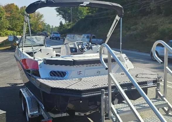 Slide: The Image of 2025 Starcraft SVX 210 DC boat on trailer, parked on roadside. - 3