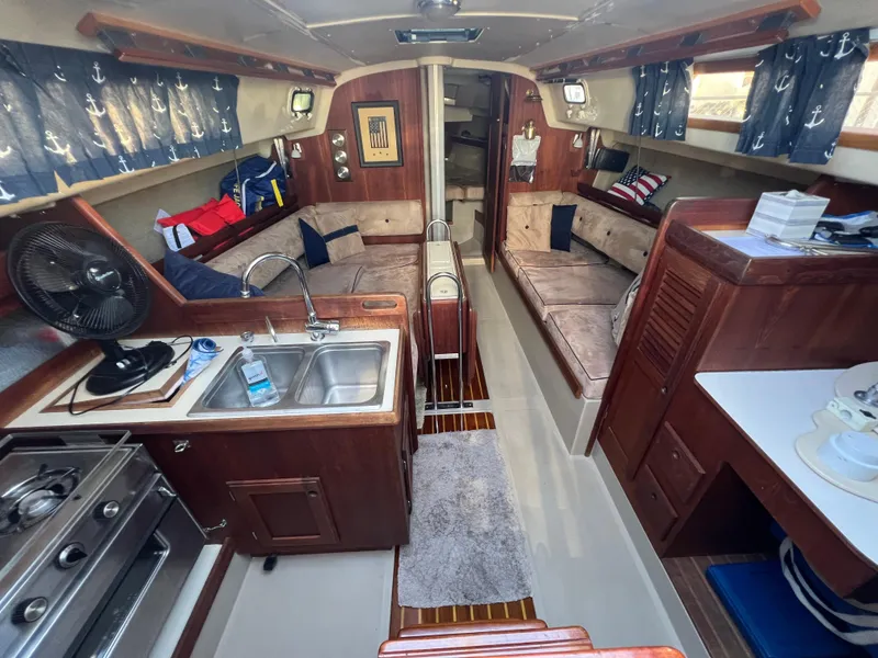 Slide: The Image of Interior of a 1983 O'Day 34 sailboat with cozy seating and kitchen area. - 18