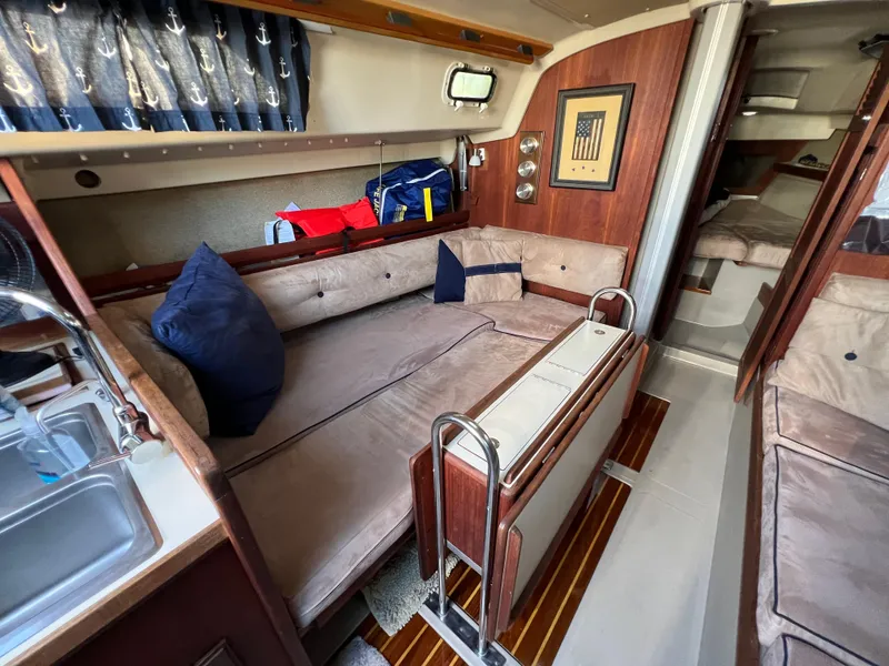 Slide: The Image of 1983 O'Day 34 sailboat interior with cozy seating and nautical decor. - 24