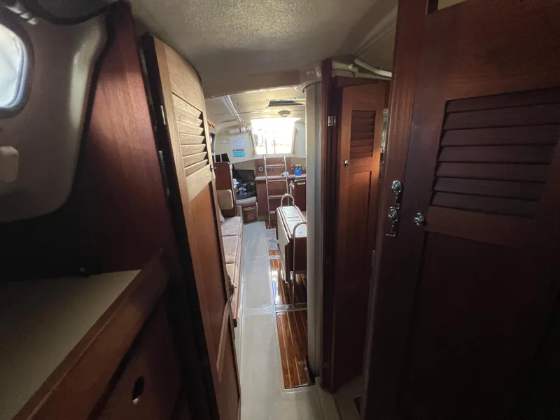 Slide: The Image of Interior of 1983 O'Day 34 sailboat with wooden cabinetry and cozy seating area. - 32