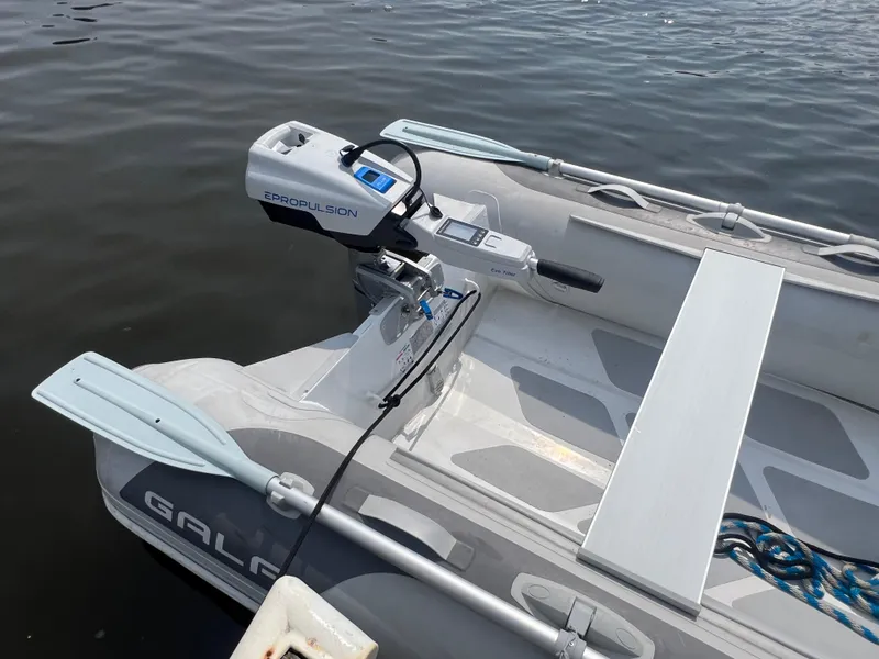 Slide: The Image of Inflatable boat with ePropulsion motor on calm water, featuring oars and a bench seat. - 4