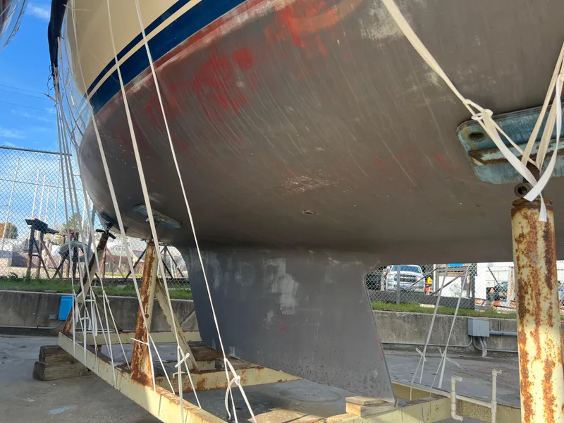 Slide: The Image of 1983 O'Day 34 sailboat hull on dry dock, showing keel and support structure. - 46