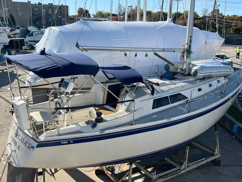 Slide: The Image of 1983 O'Day 34 sailboat with blue canopy, docked in a marina. - 5