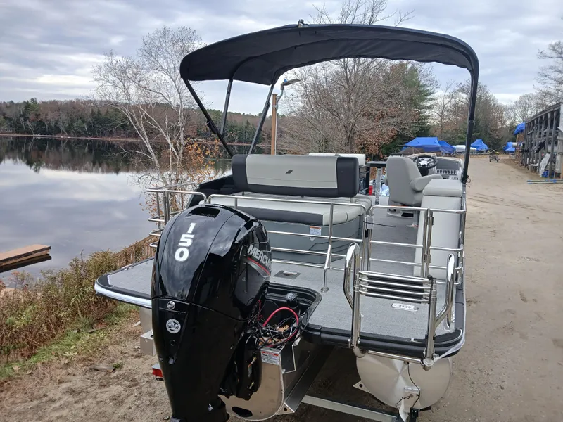 Slide: The Image of 2025 Starcraft EXS 1 Q DH pontoon boat with 150 HP engine by a lake. - 3