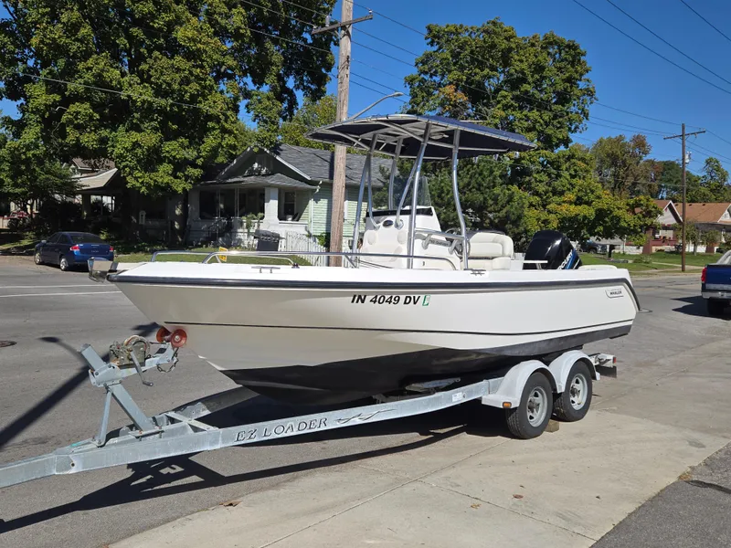 Slide: The Image of 2004 Boston Whaler 210 Outrage boat on trailer, parked on street. - 2