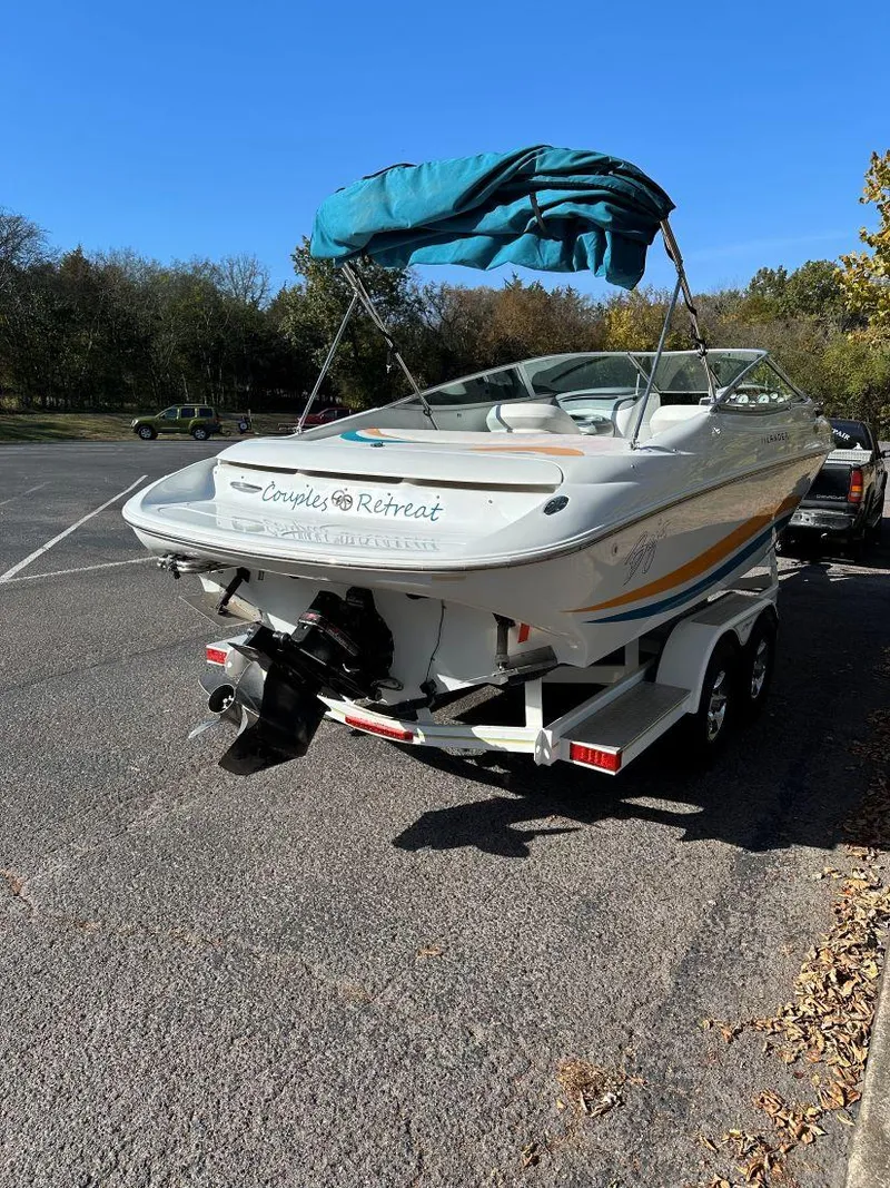 Slide: The Image of 1995 Baja 272 Islander boat on trailer in parking lot, blue canopy, sunny day. - 3