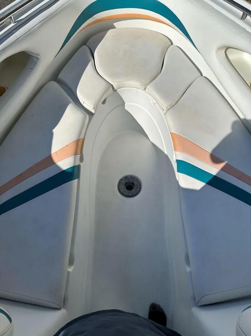 Slide: The Image of 1995 Baja 272 Islander boat interior with cushioned seating and colorful stripes. - 9