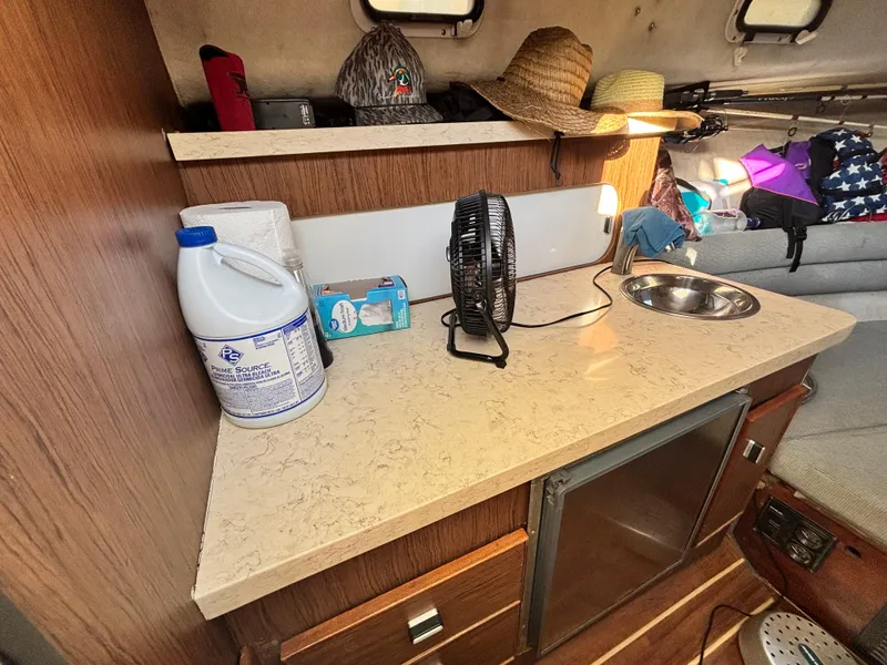 Slide: The Image of 1992 Pursuit 2800 Open cabin interior with countertop, sink, fan, and storage. - 10