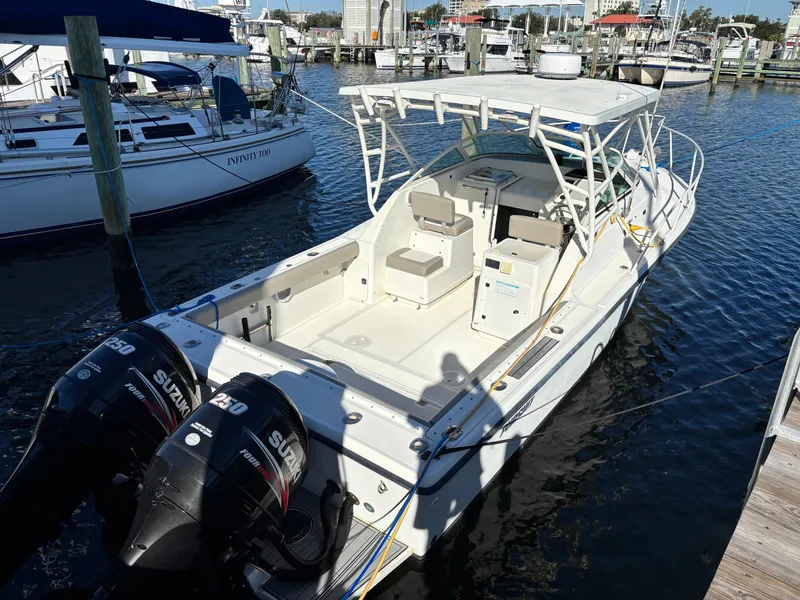 Slide: The Image of 1992 Pursuit 2800 Open boat docked with dual Suzuki engines. - 2