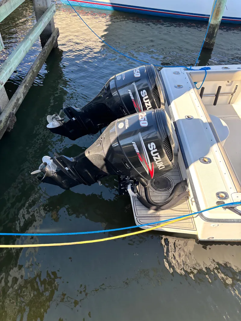Slide: The Image of 1992 Pursuit 2800 Open with twin Suzuki outboard motors docked in water. - 3