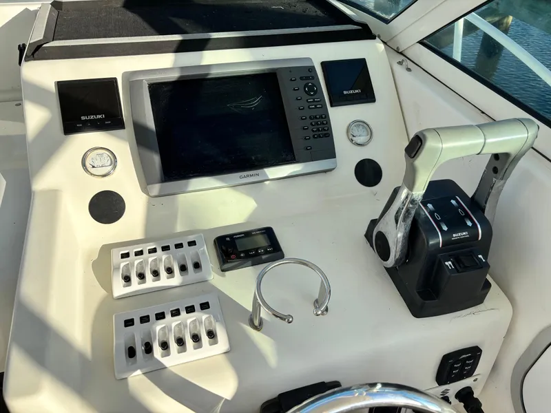 Slide: The Image of 1992 Pursuit 2800 Open boat dashboard with Garmin navigation and Suzuki controls. - 5