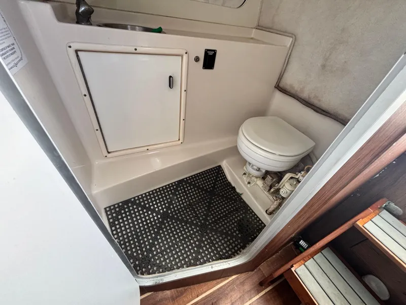 Slide: The Image of 1992 Pursuit 2800 Open boat bathroom with toilet and sink. - 7