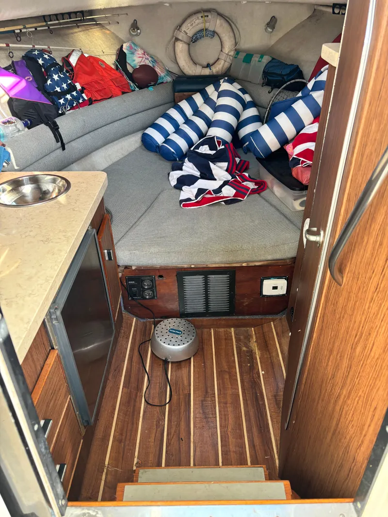Slide: The Image of Cozy cabin interior of a 1992 Pursuit 2800 Open boat with striped cushions. - 9