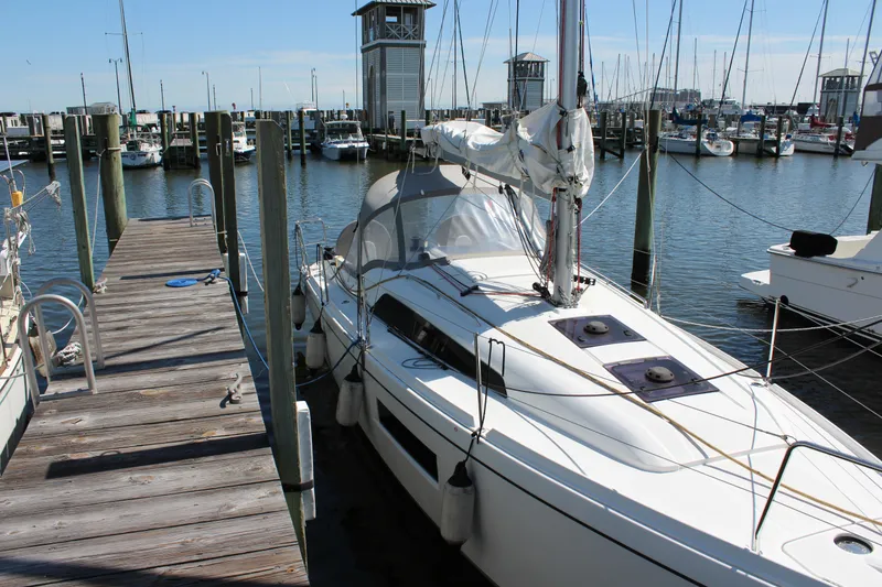 The Image of 2022 Beneteau Oceanis 30.1 yacht docked at a marina, surrounded by other boats. - 0
