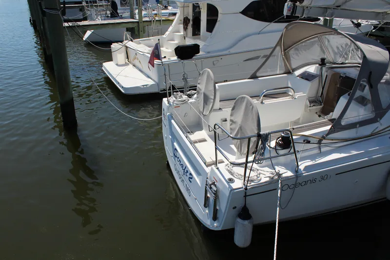 Slide: The Image of Beneteau Oceanis 30.1 sailboat docked, 2022 model, with covered seating and nautical equipment. - 3