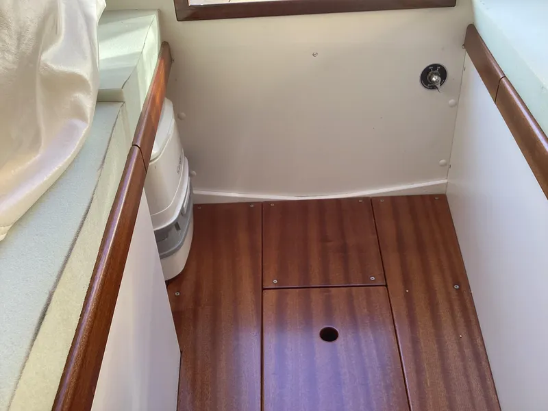 Slide: The Image of 2024 MacKenzie Cuttyhunk boat interior with wood flooring and seating. - 17