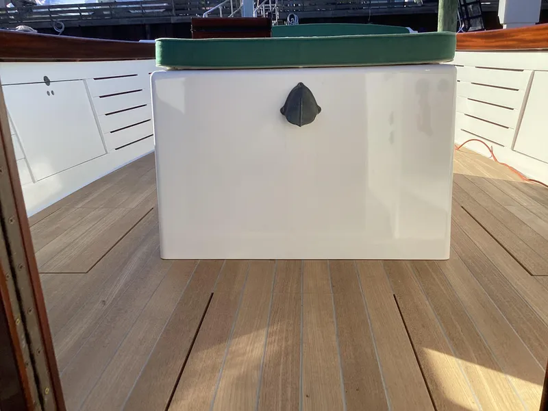 Slide: The Image of 2024 MacKenzie Cuttyhunk boat interior with wooden deck and white storage compartment. - 18