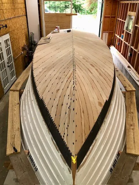 Slide: The Image of 2024 MacKenzie Cuttyhunk boat under construction in a workshop. - 33