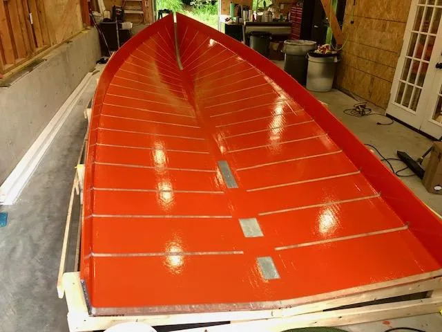 Slide: The Image of Red MacKenzie Cuttyhunk 2024 boat hull in workshop, showcasing glossy finish. - 35