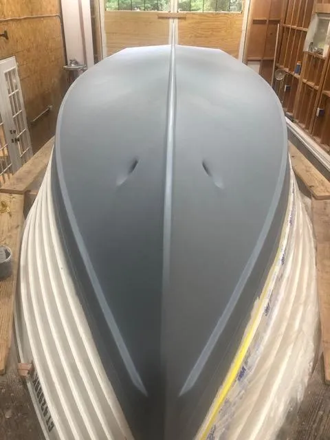 Slide: The Image of 2024 MacKenzie Cuttyhunk boat hull in workshop, showcasing sleek design and craftsmanship. - 38