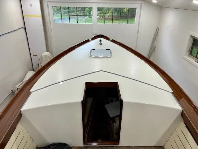 Slide: The Image of 2024 MacKenzie Cuttyhunk boat in garage, showcasing sleek design and wooden accents. - 42