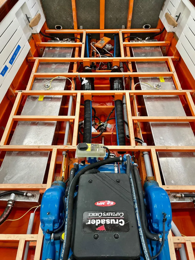 Slide: The Image of 2024 MacKenzie Cuttyhunk boat engine compartment with Crusader engine and visible framework. - 45