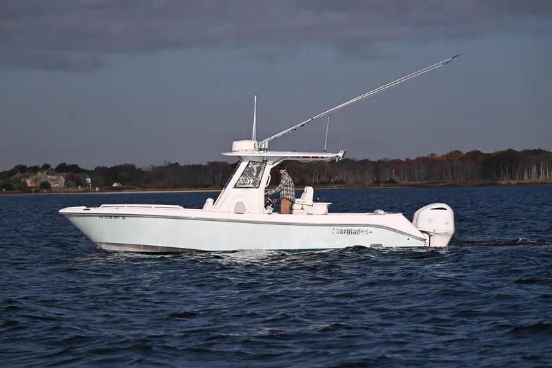 Slide: The Image of 2019 Everglades 295 Center Console boat cruising on open water. - 15