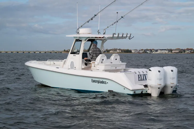 Slide: The Image of 2019 Everglades 295 Center Console boat on open water, equipped with dual engines. - 18