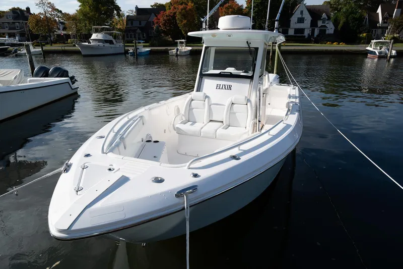 Slide: The Image of 2019 Everglades 295 Center Console boat docked in a scenic marina. - 23