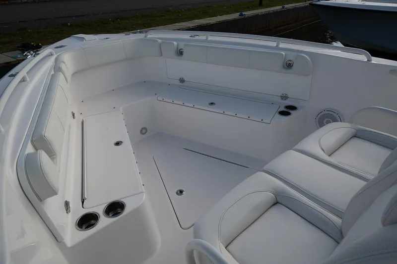 Slide: The Image of 2019 Everglades 295 Center Console boat interior with white seating and cup holders. - 25