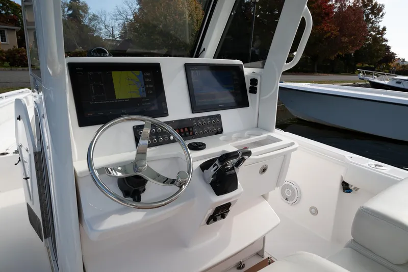 Slide: The Image of 2019 Everglades 295 Center Console boat dashboard with steering wheel and navigation screens. - 35