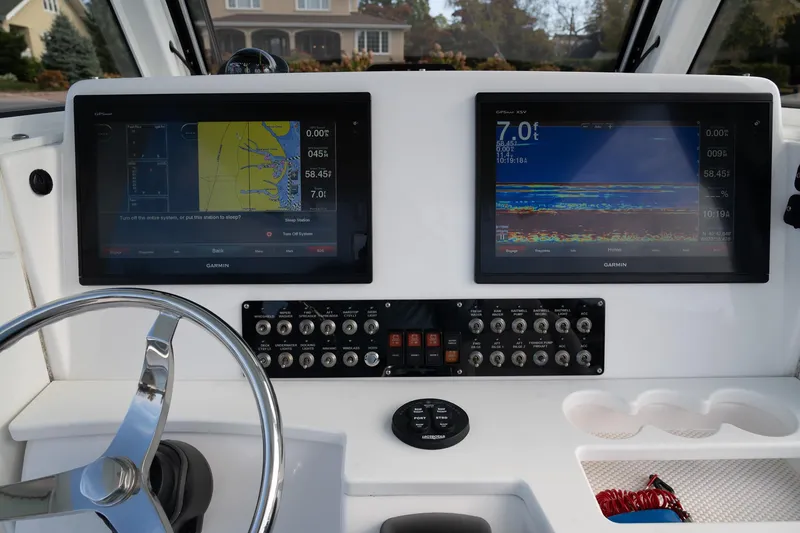 Slide: The Image of 2019 Everglades 295 Center Console dashboard with dual navigation screens and control panel. - 38