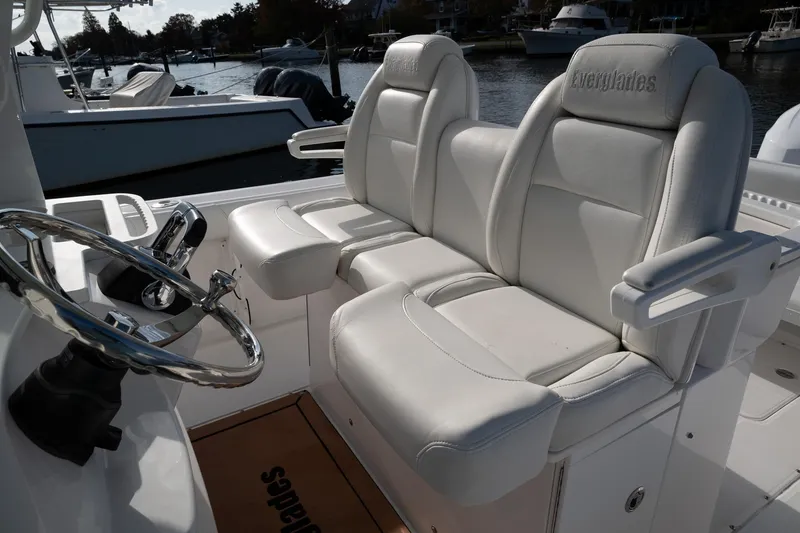 Slide: The Image of 2019 Everglades 295 Center Console boat with white leather seating and steering wheel. - 41