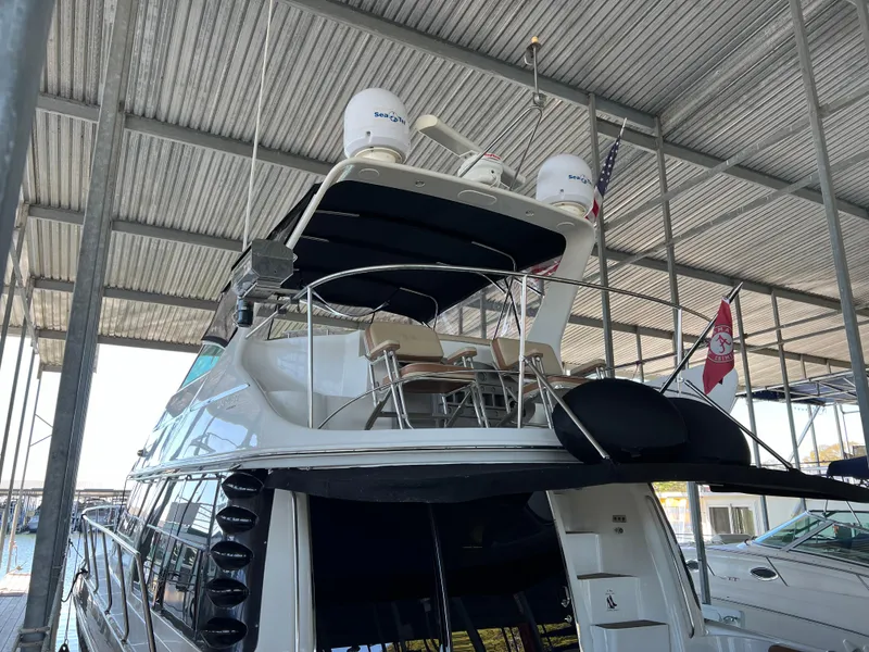 Slide: The Image of 2001 Carver 450 Voyager Pilothouse yacht docked under a covered marina. - 12