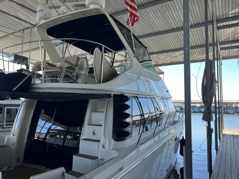 Slide: The Image of 2001 Carver 450 Voyager Pilothouse yacht docked under a covered marina. - 14