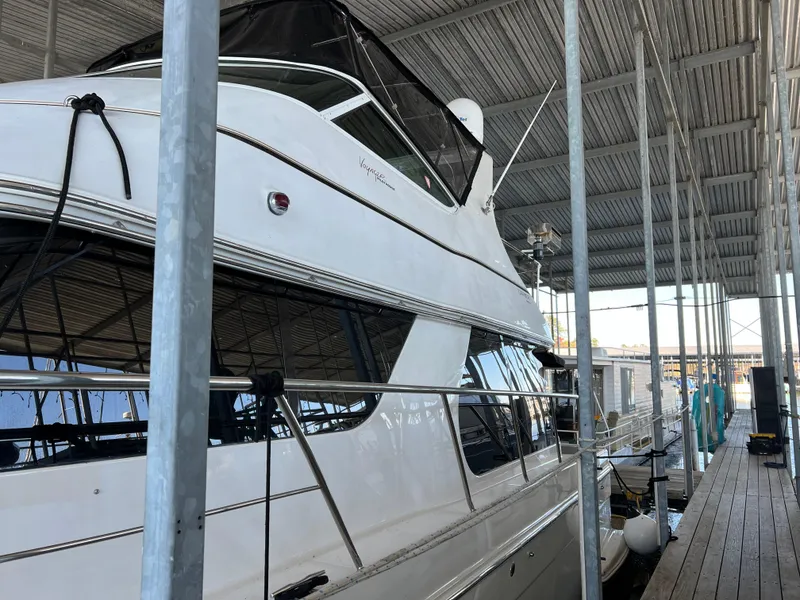 Slide: The Image of 2001 Carver 450 Voyager Pilothouse yacht docked under a covered marina. - 2