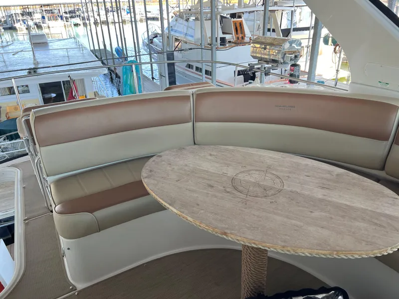 Slide: The Image of 2001 Carver 450 Voyager Pilothouse yacht interior with curved seating and wooden table. - 26