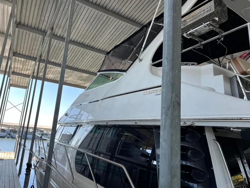 Slide: The Image of 2001 Carver 450 Voyager Pilothouse yacht docked under a covered marina. - 7